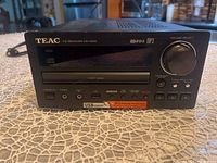 Front view showing TEAC CD Receiver CR-H225 model with volume/select knob, USB port, power, and CD control buttons