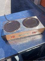 Top view showing two circular heating plates with signs of use and two red on/off switches.