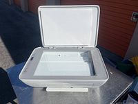 Top angled view of HP DeskJet 2755 printer with lid open showing scanner glass bed inside.