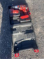 Photo of red and black JobMate cordless drill inside black plastic carrying case, showing the 18.0V battery attached to the drill and empty compartments in case.