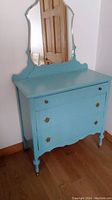 Full view of the blue painted dresser with attached mirror against wall