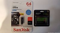 Front photo of the unopened SanDisk Ultra 64GB USB 3.0 flash drive and ADATA 240GB SU650 solid state drive in original packaging.