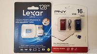 Front view of unopened Lexar 128GB microSDXC UHS-I memory card in retail packaging and PNY USB flash drives 2 pack with red and blue drives.