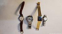 Overview photo of four wristwatches showing different styles, dials and straps