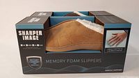 Tan memory foam slipper in original Sharper Image box showing side profile and plush white lining.