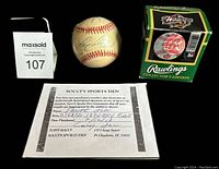 Photo of the autographed baseball, COA, and Rawlings box together on black background