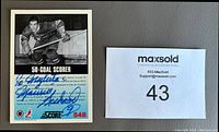 Back side of the signed hockey card showing Maurice Richard's autograph in blue Sharpie, with printed bio and stats.