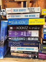 Stack of Dean Koontz novels including The Eyes of Darkness, Fear Nothing, Silent Corner, The Face, Relentless, Watchers, Shadowfires, The Vision, and others.