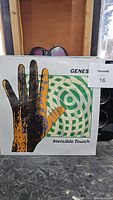 Genesis Invisible Touch vinyl record front cover showing stylized hand and circular pattern artwork