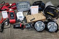 Full lot overview showing all items including battery charger, inverter, lights, air pumps, and rear view camera.