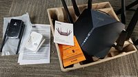 Photo showing D-Link DIR-3040 router with two WiFi extenders and quick install guides.