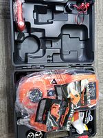 Overview photo of the orange hydraulic floor jack and plastic carrying case with compartments for tools and accessories.