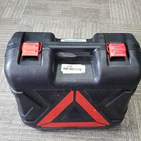 Closed carrying case with red triangle and latches visible