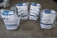 Four Levoit cool mist humidifiers in original plastic bags, placed upright on a carpeted surface.