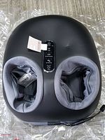 Foot massager with dual padded foot chambers and control panel on top.