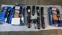 Overall lot showing multiple Philips trimmers including multiple Multigroom 7000 and Series 3000 devices out of packaging, some plugged with charger cords.