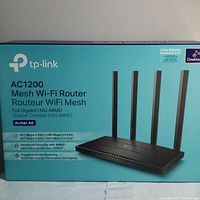 Packaging box front showing TP-LINK AC1200 Mesh Wi-Fi Router Archer A6 branding with product image and features.