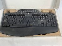 Black Logitech MK700/710 wireless keyboard showing the front with cushioned palm rest and additional function keys, stored in tray packaging.