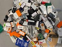 Image showing a large assortment of unopened blade packs in various brands and colors scattered on a surface.