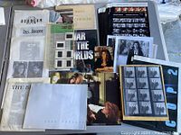 Overview of lot showing assorted vintage photos, posters, books, and slides packed closely together on a surface