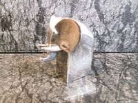 Front and side views of small silverplated elephant figurine showing smooth reflective surfaces and stylized design.