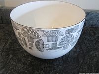 Full view of white enamel bowl with black mushroom design on exterior