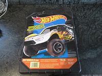 Front view of Hot Wheels carrying case displaying the Hot Wheels brand logo and a large monster truck with flame decals printed on the case.