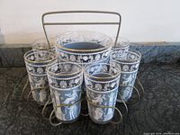 Full set includes eight tumblers and ice bucket in metal wire carrier on countertop.