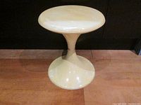 Full view of the side table showing its figure-eight shape and gold band at the narrowest point.