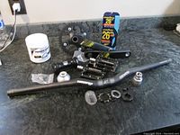 Overview photo showing bike parts including handlebar, crankset, pedals, headset parts, and tire in packaging