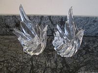 Pair of Rosenthal Studio Line flame-shaped crystal candle holders standing side by side on granite counter, showing front and side profile.