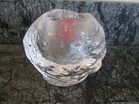 Top-down angled view of clear textured glass snowball candle holder showing the round opening at the top for tea light or votive candle.