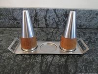 Front view of the set on black granite, showing the tray holding the salt and pepper shakers spaced apart.