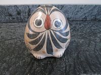 Front view of the vintage owl figurine showing painted eyes, nose, and stylized black feathers.
