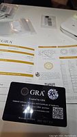 GRA certificate and warranty card laid on paper showing grading report