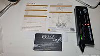 Certification documents and anti-counterfeit card by GRA Moissanite showing grading information for the 1 ct gemstone.