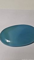 Top view of ice blue chalcedony oval cabochon showing smooth surface and uniform blue color.