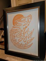 Framed original acrylic painting by Bruce Wynne, with a stylized Native American inspired abstract design in burnt orange and white, signed and displayed vertically.