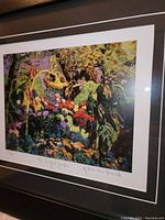 Close-up of fine art print depicting colorful garden scene with signature and title visible on white matting.