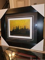 Framed print showing full view of artwork and black wooden frame with protective corner covers.