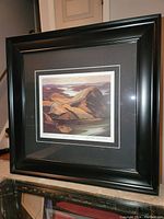 Photo showing the full framed print with black wide frame and matting around the artwork.