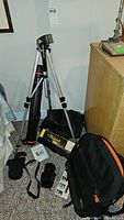 Photo showing full lot with tripod, telescope tube, camera accessories, carrying backpack, and binocular case.