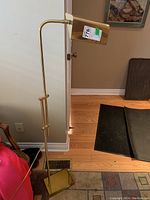 Full view of the metal floor lamp with square base and adjustable height rod, showing overall structure and finish.