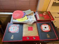 Overview of keepsake folder opened to show stamps and paper die cut fans placed inside.