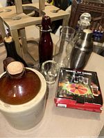 Overall group of vintage barware including Western Stoneware jug, shaker, shot glasses, glass bottles, wooden caddy, and party game