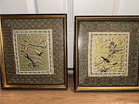 Two framed vintage oriental silk artworks depicting hummingbirds and flowers, showing the full lot.