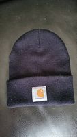 Front view of black Carhartt winter hat beanie showing the logo patch on the folded cuff