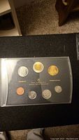 Full front view of set in display case with all seven coins visible including the Terry Fox one cent coin