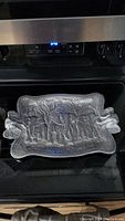 Front view of the heavy metal serving tray showing embossed elephant design and elephant head handles.