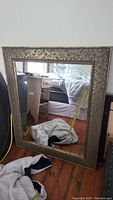 Full view of the large mirror showing ornate floral pattern frame
